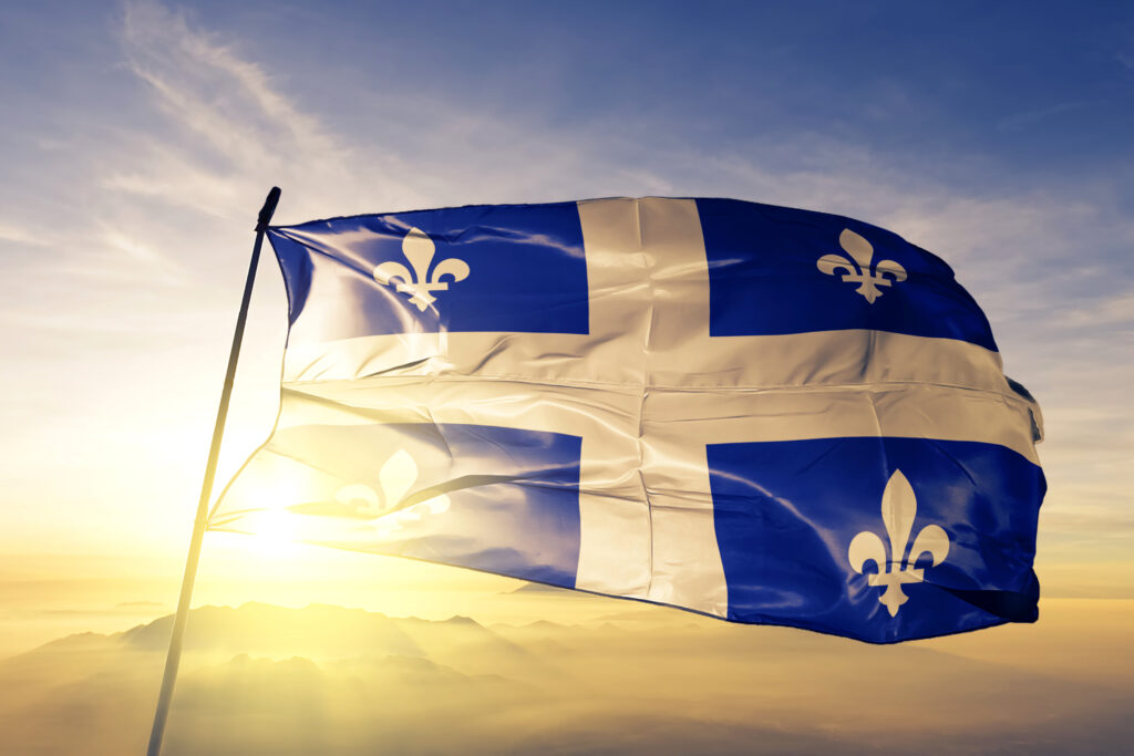 Quebec province of Canada flag textile cloth fabric waving on the top sunrise mist fog Drapeau du Québec