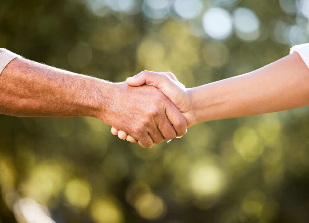 Shot of two unrecognisable men shaking hands outdoors