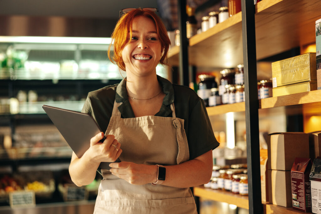 Cheerful grocery store owner smiling in her shop